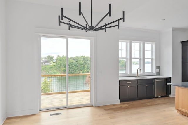 unfurnished dining area featuring sink, light hardwood / wood-style flooring, and a wealth of natural light