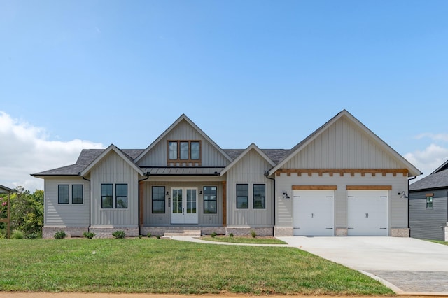 view of front facade with a garage, a front yard, and french doors