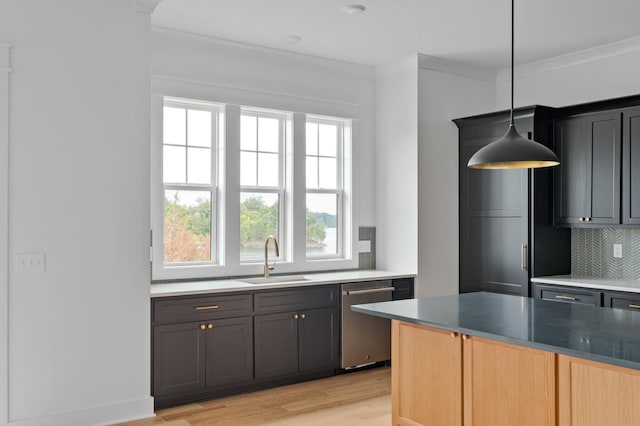 kitchen with pendant lighting, sink, decorative backsplash, stainless steel dishwasher, and light hardwood / wood-style floors