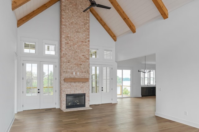 unfurnished living room featuring hardwood / wood-style flooring, french doors, and beamed ceiling