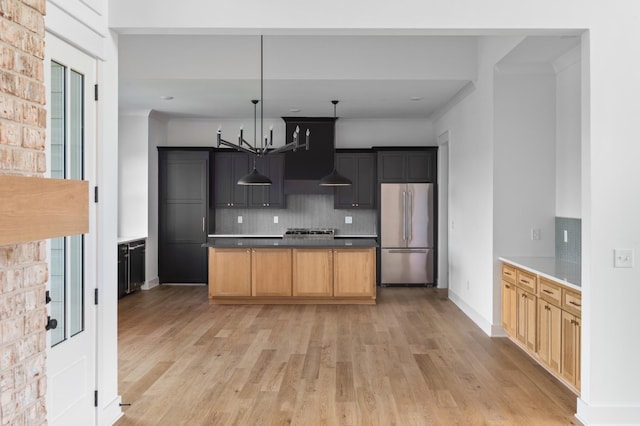 kitchen featuring a chandelier, high quality fridge, light brown cabinetry, and light wood-type flooring