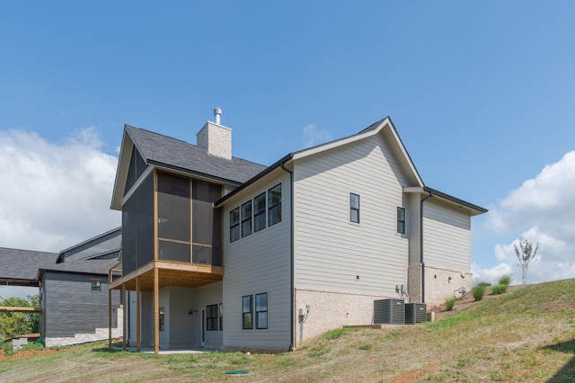 rear view of property featuring central AC and a sunroom