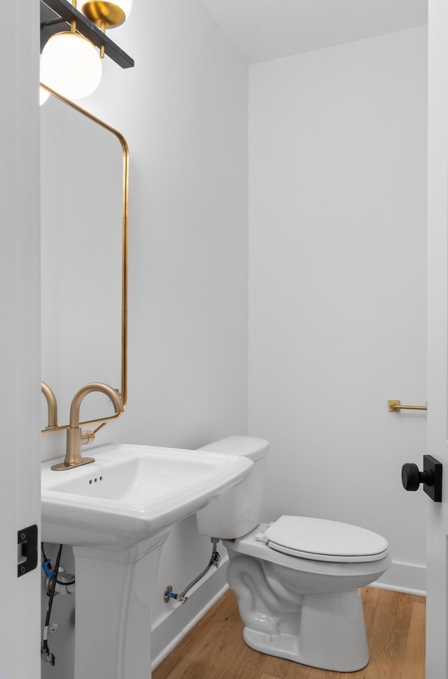 bathroom with hardwood / wood-style floors, sink, and toilet