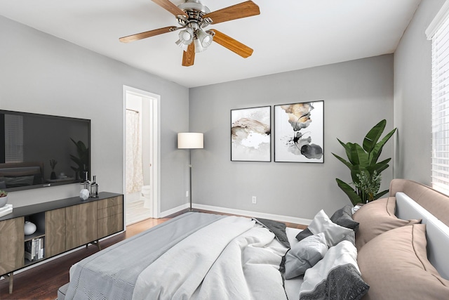 bedroom featuring hardwood / wood-style flooring, ceiling fan, ensuite bath, and multiple windows