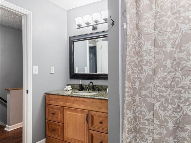 bathroom featuring vanity, a shower, and a textured ceiling