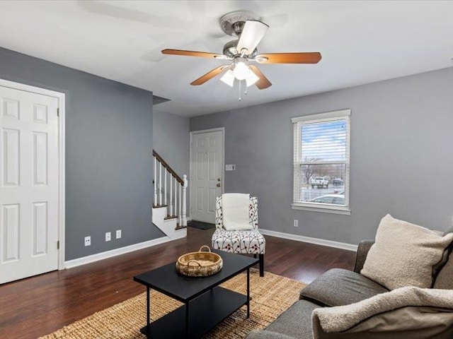 living room with dark wood-type flooring and ceiling fan