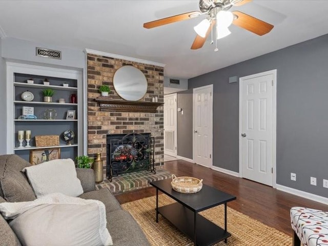 living room with built in shelves, a fireplace, dark hardwood / wood-style floors, and ceiling fan