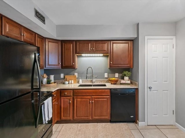 kitchen with sink, light tile patterned floors, and black appliances