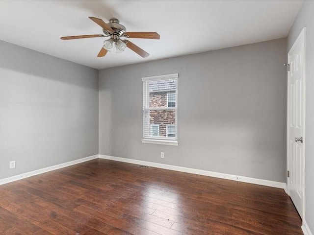 spare room with dark hardwood / wood-style floors and ceiling fan