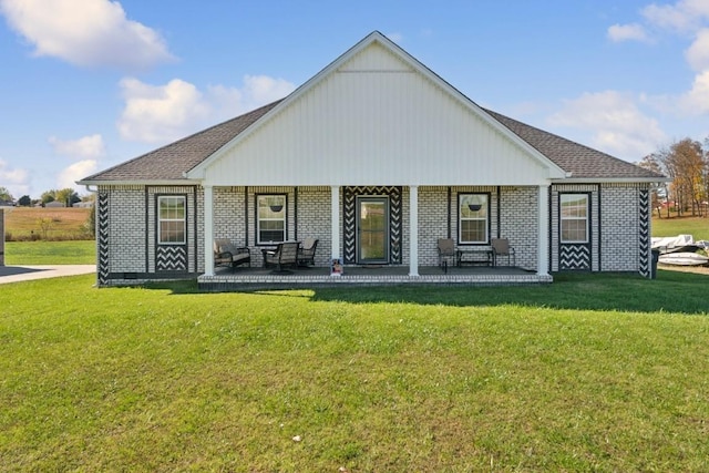 rear view of house with covered porch and a lawn