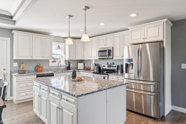 kitchen featuring stainless steel appliances, a center island, sink, and white cabinets