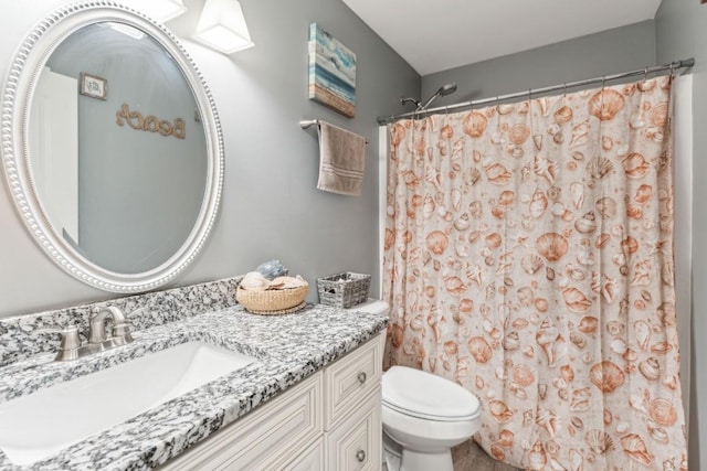 bathroom with vanity, curtained shower, and toilet