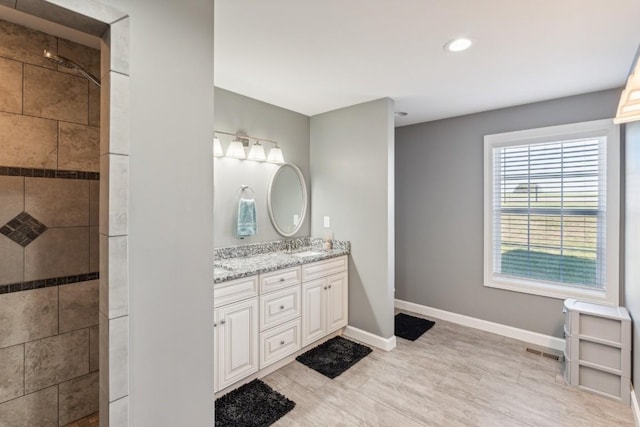 bathroom with vanity and a tile shower