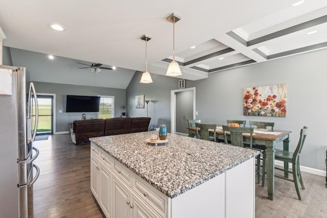 kitchen with a kitchen island, hardwood / wood-style floors, stainless steel refrigerator, decorative light fixtures, and white cabinets