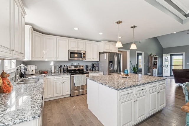 kitchen featuring a kitchen island, appliances with stainless steel finishes, pendant lighting, sink, and white cabinets