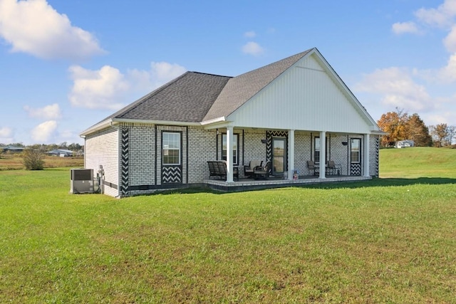 rear view of property featuring a yard, central AC, and a patio