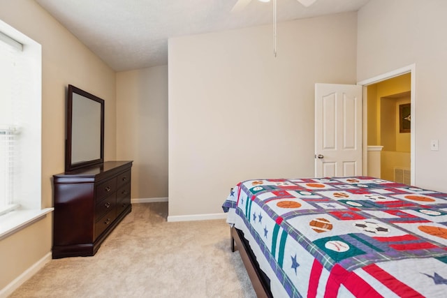 bedroom with light carpet, visible vents, baseboards, and ceiling fan