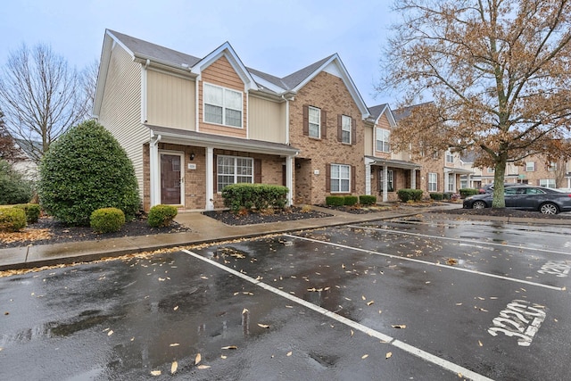 view of front of home featuring uncovered parking and brick siding