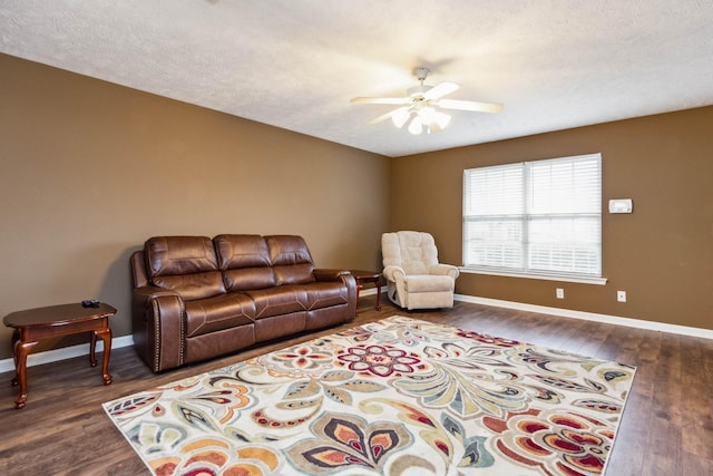 living room with dark hardwood / wood-style flooring, a textured ceiling, and ceiling fan