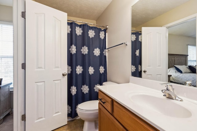 bathroom with vanity, toilet, and a textured ceiling