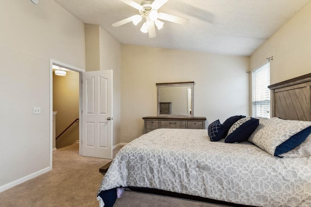 bedroom with a ceiling fan, light carpet, vaulted ceiling, and baseboards