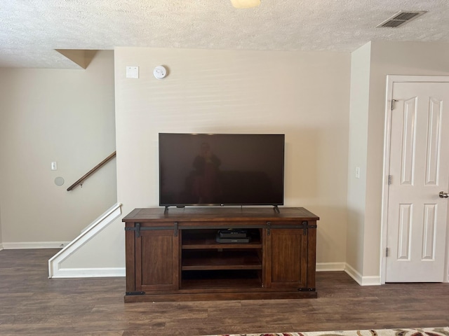 details with visible vents, a textured ceiling, baseboards, and wood finished floors