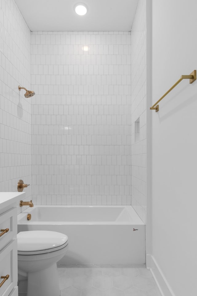 full bathroom with tile patterned flooring, vanity, tiled shower / bath combo, and toilet