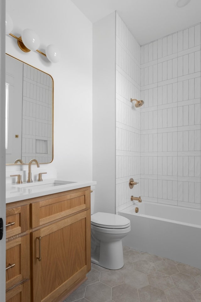 full bathroom featuring vanity, toilet, tiled shower / bath combo, and tile patterned flooring