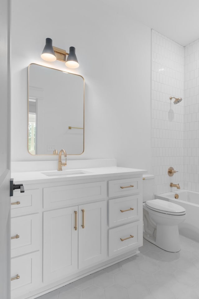 full bathroom featuring tiled shower / bath, vanity, toilet, and tile patterned floors