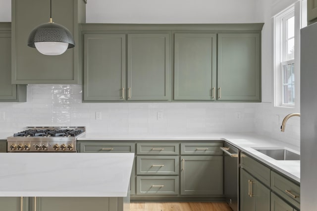 kitchen featuring sink, light stone countertops, green cabinetry, and appliances with stainless steel finishes