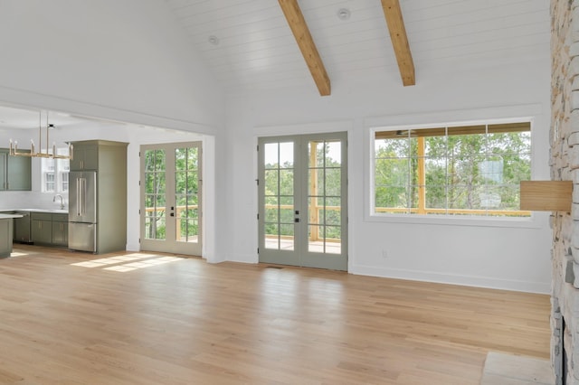 unfurnished living room featuring sink, light hardwood / wood-style flooring, beam ceiling, high vaulted ceiling, and french doors