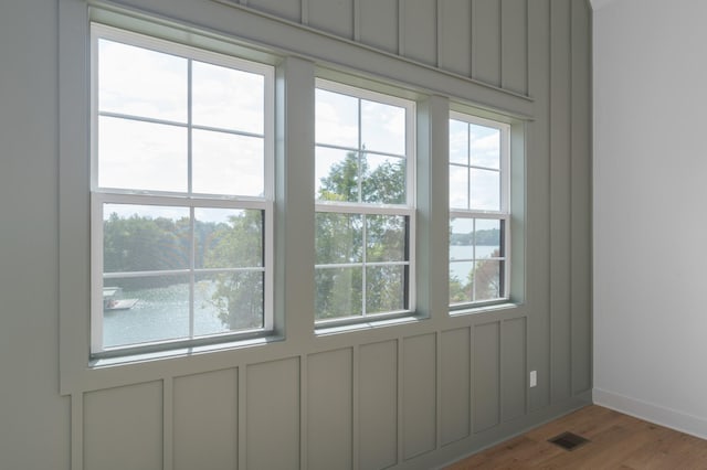 doorway with a water view and light hardwood / wood-style flooring