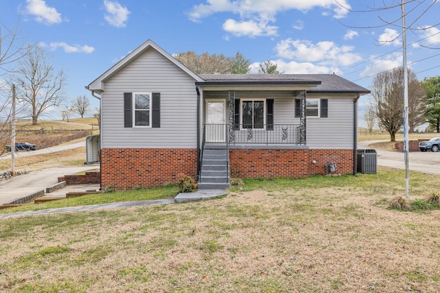 view of front of house with cooling unit, a front yard, and covered porch