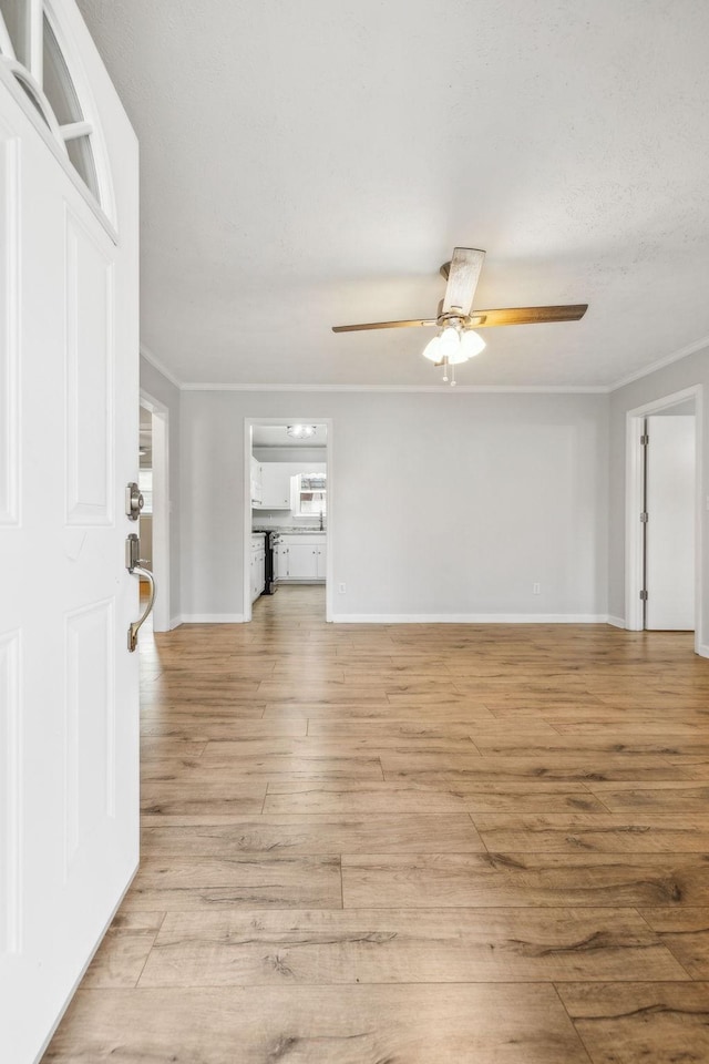 unfurnished living room featuring crown molding, light hardwood / wood-style flooring, and ceiling fan