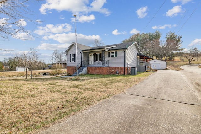 view of front of house with central AC, a front yard, covered porch, and a storage shed