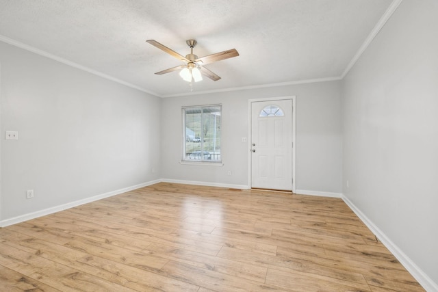 spare room with a textured ceiling, light hardwood / wood-style flooring, ornamental molding, and ceiling fan