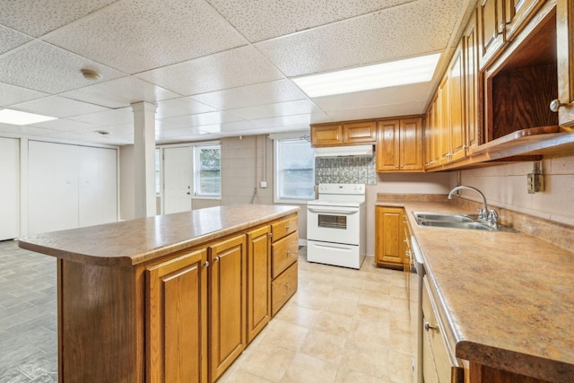 kitchen with sink, a paneled ceiling, white electric stove, and a center island