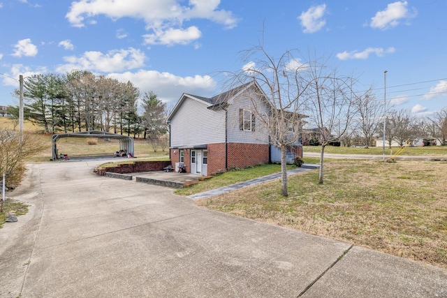 view of side of property with a carport and a lawn