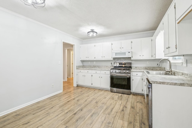 kitchen with white cabinetry, appliances with stainless steel finishes, and light hardwood / wood-style floors