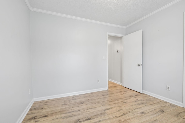 empty room with crown molding, light hardwood / wood-style floors, and a textured ceiling