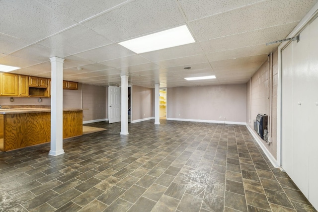 basement with a drop ceiling and heating unit