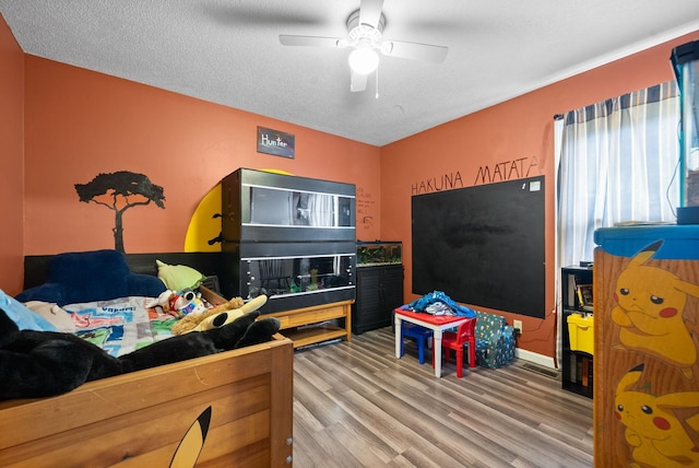 bedroom featuring hardwood / wood-style flooring, a textured ceiling, and ceiling fan