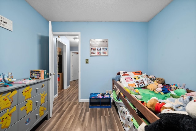 bedroom with dark wood-type flooring and a textured ceiling