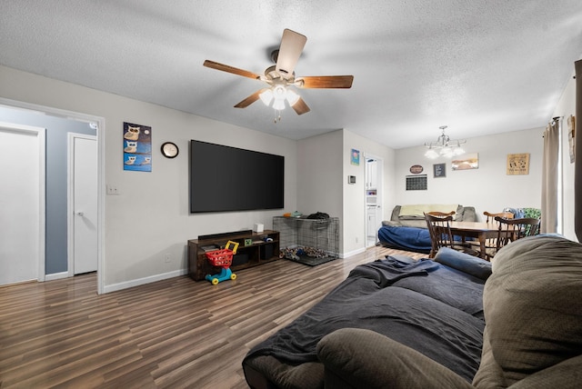 living room featuring wood-type flooring, ceiling fan with notable chandelier, and a textured ceiling