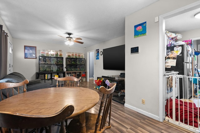 dining room with ceiling fan, wood-type flooring, and a textured ceiling