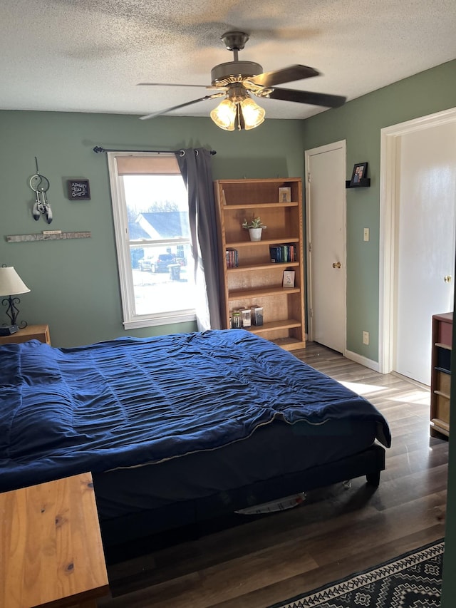 bedroom featuring hardwood / wood-style flooring, a textured ceiling, and ceiling fan