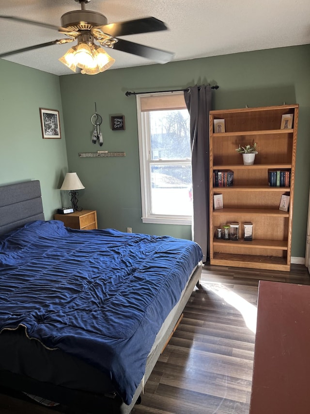 bedroom with ceiling fan, dark hardwood / wood-style floors, and a textured ceiling