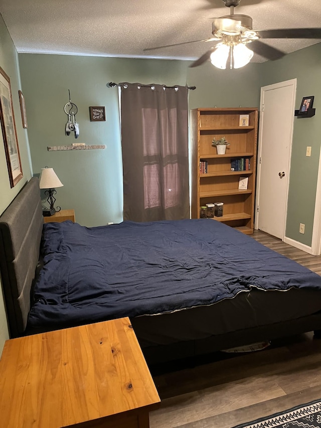 unfurnished bedroom featuring ceiling fan, hardwood / wood-style flooring, and a textured ceiling