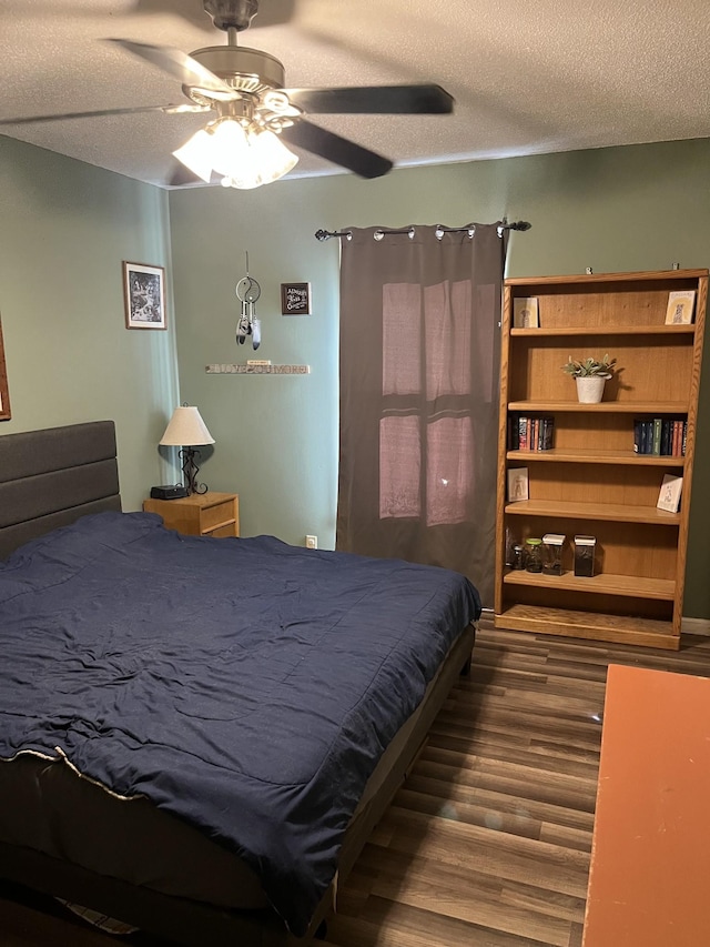 bedroom featuring ceiling fan, hardwood / wood-style flooring, and a textured ceiling