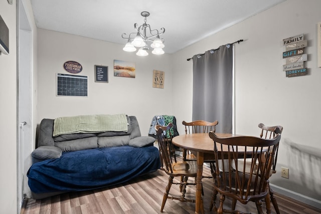 dining space featuring wood-type flooring and a chandelier